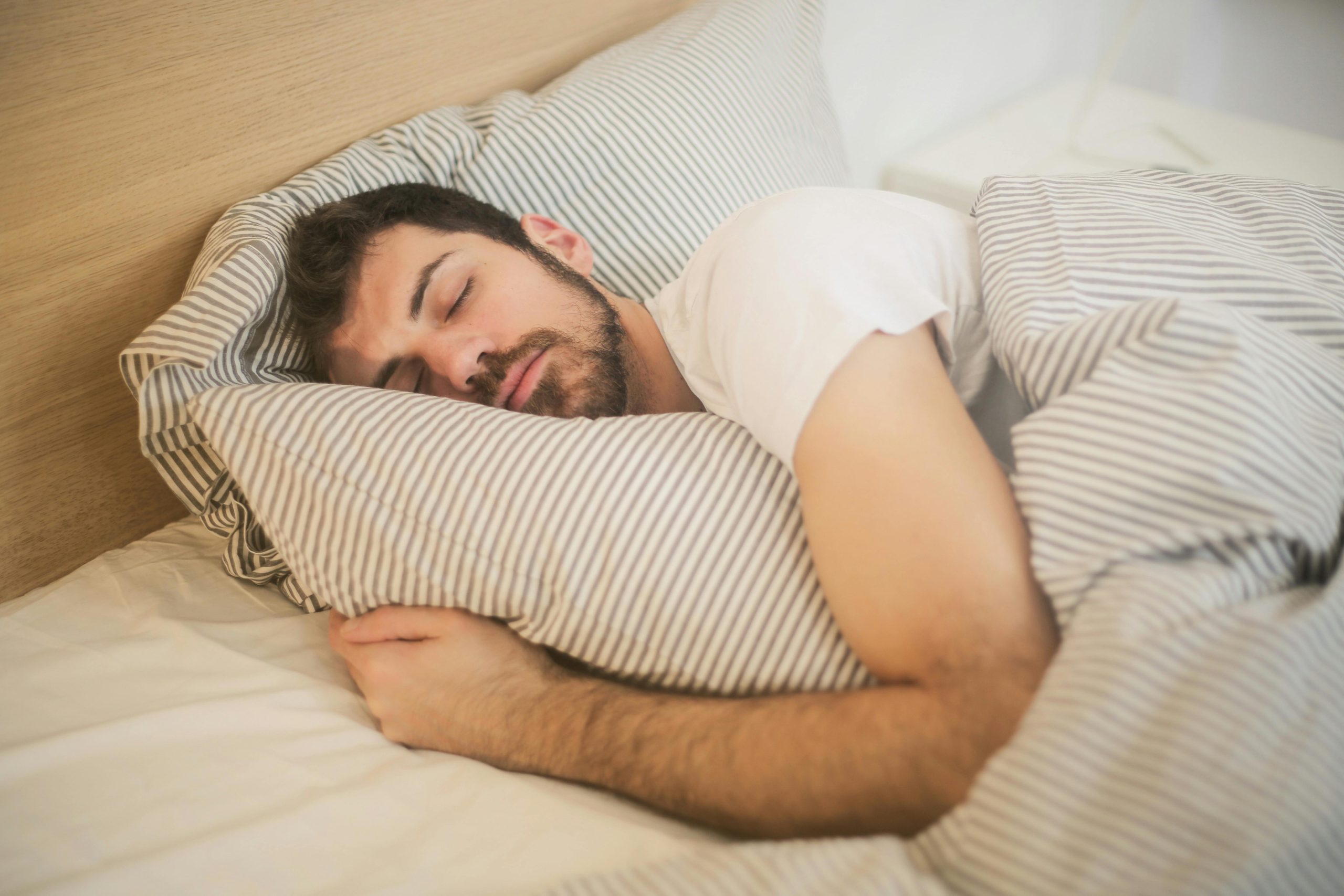 A man sleeping in his bed showing the importance of sleep and addiction recovery.